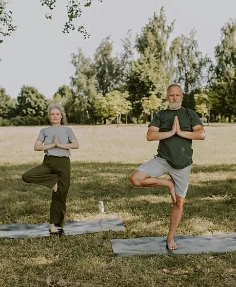 Mature couple practicing yoga outdoors